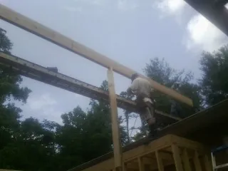 Carpenter setting a ridge beam over a new addition frame — Ice Dam Removal by Roofing Brothers in Sanborn